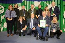 Conjunt de persones mirant al front. Una d'elles mostra el guardó.